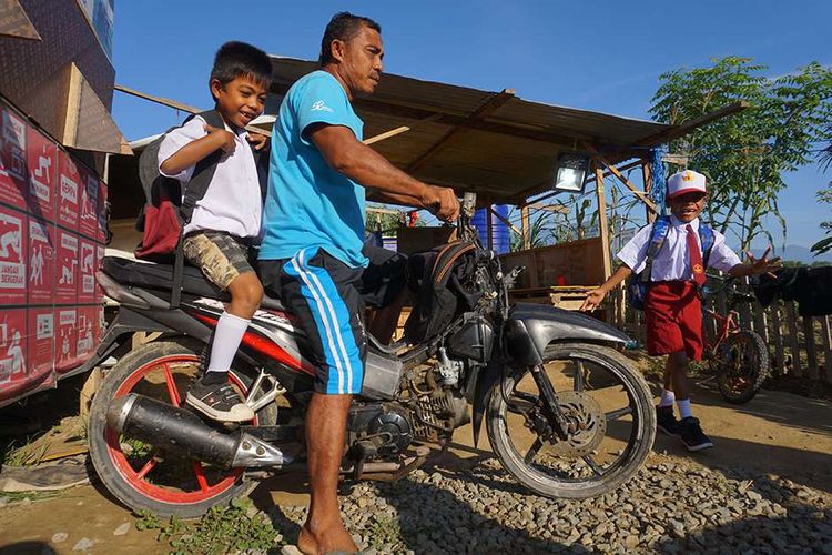 Sejumlah siswa baru bersiap menuju sekolah pada hari pertama masuk sekolah di Kamp Pengungsian Jono Oge, Kabupaten Sigi, Sulawesi Tengah, Senin (15/7/2019). Seluruh siswa SD, SMP dan SMA di daerah terdampak bencana gempa dan likuefaksi tersebut mulai masuk sekolah pada tahun ajaran baru 2019/2020.