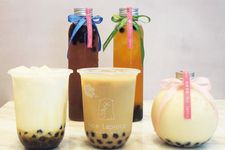 Tapioca Milk Tea (depan, tengah; &yen;500) menggunakan bola tapioka. Teh susu kedai ini disajikan dalam botol berbentuk tabung panjang. 