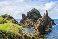 Dramatic, steep rocky volcanic islands viewed from a sea cliff in the famous Oki Islands, Japan.