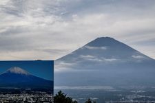 Penampakan puncak Gunung Fuji masih belum bersalju sampai 31 Oktober 2024 yang terilhat dari Gotemba, Prefektur Shizuoka (belakang). Foto bagian depan menunjukkan sebuah tanda bergambar Gunung Fuji dengan puncak bersalju.