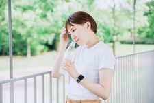 Ilustrasi perempuan memakai kaus dan membawa botol minum.