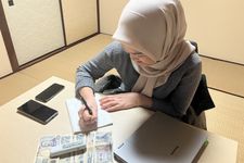 Ifah, pekerja SSW di Jepang sedang mencatat dan membagi keuangan.