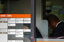 Pelanggan menggunakan ATM di cabang Japan Post di distrik perbelanjaan Ginza, pusat Tokyo, pada 26 Desember 2014.