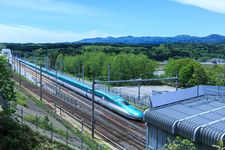 Shinkansen berwarna biru melintas di rel.