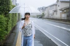 Seorang wanita mengenakan blus yang dipadu dengan outer panjang.