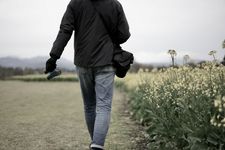 Seorang pria mengenakan outfit  jaket dan celana jeans.