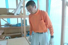 Seorang pria mengenakan outfit blus lengan panjang dengan celana bahan katun.