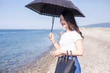 Seorang wanita mengenakan outfit kaos berbahan katun dan celana jeans.