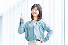Seorang wanita mengenakan outfit blus dipadupadankan dengan celana berbahan katun.