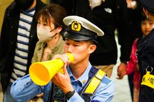 Polisi Jepang memandu kerumunan di kereta bawah tanah Tokyo.