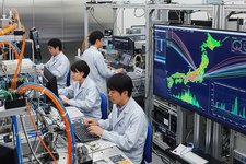 Ilustrasi laboratorium riset teknologi Jepang dengan kabel serat optik dan visualisasi data internet super cepat.