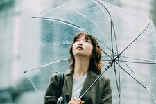 Seorang wanita mengenakan outfit kaos dengan balutan outer.