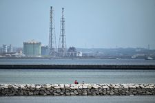 Dua orang terlihat duduk di pemecah ombak di Kota Chiba, Jepang, pada 30 Juli 2025. Wilayah pesisir Jepang siaga tsunami setelah gempa magnitudo 8,7 terjadi di laut timur Rusia. Peringatan juga berlaku di Hawaii, Rusia, Ekuador, dan pantai California.