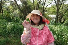 Seorang wanita mengenakan outfit kemeja panjang dengan mengenakan topi.