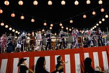 Penari mengelilingi panggung untuk menari dalam festival Obon di Jepang.
