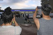 Wisatawan memotret spot viral Gunung Fuji dari balik pagar baru yang dipasang di Fujikawaguchiko, Prefektur Yamanashi, pada 14 Agustus 2025.