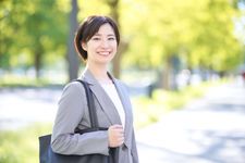 Seorang wanita mengenakan outfit blus dan blazer.