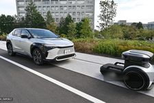 Sebuah robot otonom (kanan) memandu dan mengangkut mobil bersama di dalam kawasan &lsquo;Woven City&rsquo; milik Toyota Motor Corporation di Kota Susono, Prefektur Shizuoka, (25/9/2025). Produsen mobil terlaris Toyota meresmikan desa berteknologi tinggi baru di Jepang, sebagai proyek eksperimental untuk menguji kendaraan otonom dan berbagai inovasi futuristik.