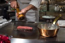 Ilustrasi koki sedang mengolah daging sapi wagyu di restoran fine dining Jepang. 