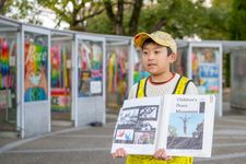Shun Sasaki memandu wisatawan mancanegara berkeliling Taman Peringatan Perdamaian menggunakan dokumen buatan tangan.