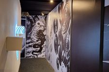 Lorong sempit yang dipenuhi lukisan dengan tone warna gelap dan nuansa horor yang khas dari gaya artistik Junji Ito.