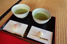 Nampan teh Jepang dengan dua cangkir matcha beserta beberapa kue manis selama upacara teh di Taman Hamarikyu, Tokyo, Jepang.