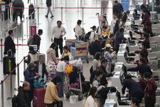 Orang-orang check-in untuk penerbangan mereka, termasuk yang menuju Jepang, di Bandara Internasional Ibu Kota Beijing di Tiongkok pada 15 November 2025.