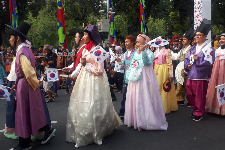 Para peserta yang mengenakan pakaian tradisional masyarakat Korea Selatan yakni Hanbok dengan nuansa warna biru, merah muda, dan putih pada parade Jakarnaval 2019.