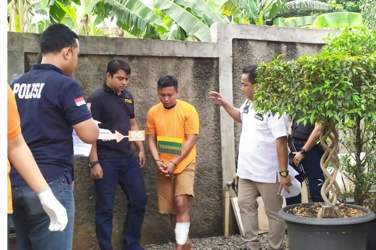 Baharudin, tersangka pembunuhan dan perampokan (tengah) saat prarekonstruksi di Limo, Cinere, Depok, Selasa (2/7/2019).