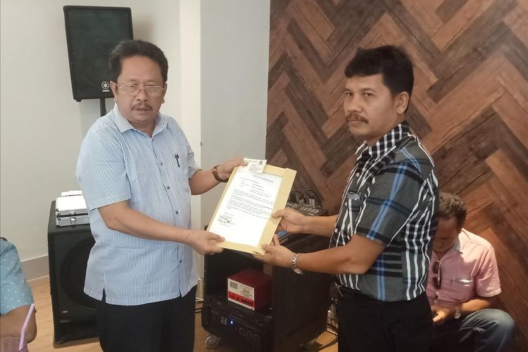 Pendiri Perindo Sumbar HM Tauhid (kiri) menyerahkan surat pengunduran dirinya kepada kepala sekretariat Perindo Sumbar, Zubir, Kamis (4/7/2019)