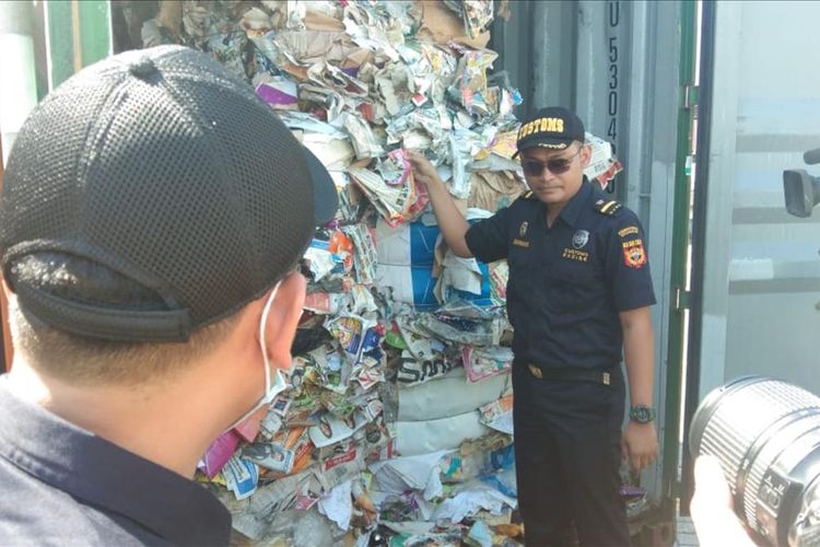 Petugas Kantor Bea Cukai Tanjung Perak melakukan pemeriksaan fisik delapan kontainer importasi waste paper dari Australia yang terkontaminasi limbah B3 di Pelabuhan Peti Kemas, Surabaya, Selasa (9/7/2019).