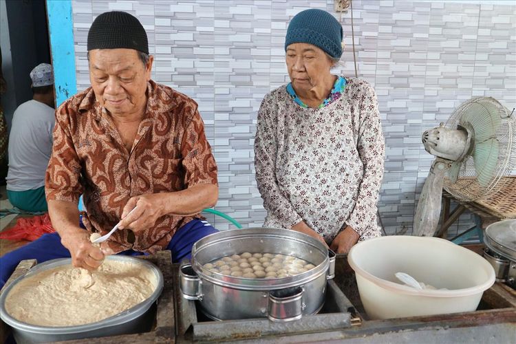 Samsuri (72) didampingi istrinya, Siti Mukianik (67), saat mempraktekkan sisa kemampuannya membuat 'pentol' bakso, Kamis (11/7/2019). Pasangan suami istri asal Desa Mojowarno, Kabupaten Jombang, Jawa Timur, tersebut akan berangkat haji berkat rutinitas menabung dari hasil berjualan bubur, sejak tahun 2007.