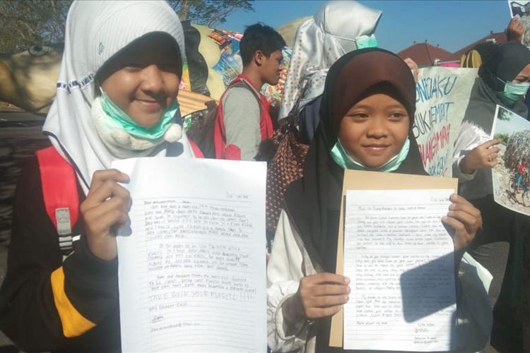 Esnina Azzahra Kirani (12) dan Hera Zaki (11) menunjukkan surat yang ia tujukan untuk Presiden Donald Trump saat menggelar demonstrasi di Kantor Konsulat Jenderal Amerika Serikat di Surabaya, Jumat (12/7/2019).