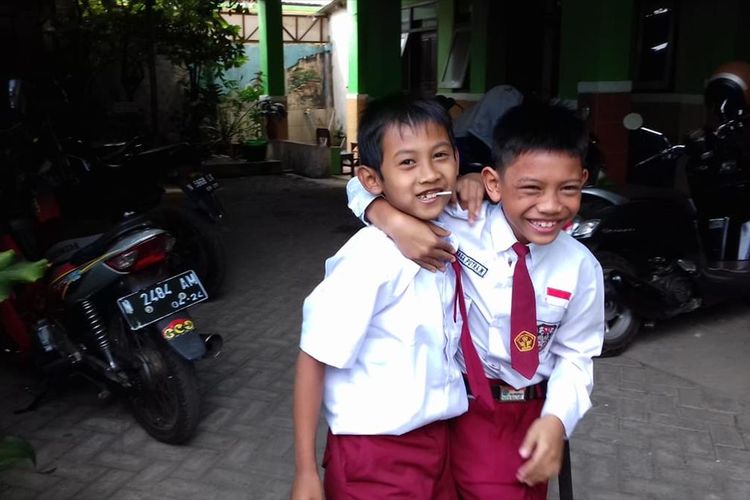 Naga Putra Wicaksana (kanan) saat bermain bersama temannya di SDN Blimbing 5 Kota Malang, Senin (15/7/2019)