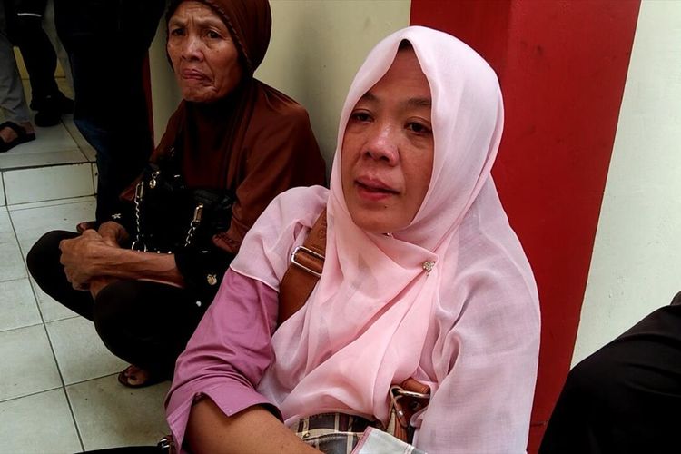 Romdania (44) ibunda Obby Frisman Arkataku (24) usai membesuk anaknya di Polresta Palembang, Kamis (18/7/2019).