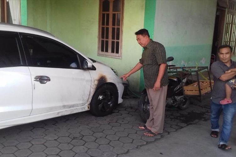 Kondisi mobil jenis MPV milik Sulaiman (54), warga Desa Peterongan, Kecamatan Peterongan, Kabupaten Jombang, Jawa Timur. Mobil warna putih itu dilempar bom oleh orang misterius saat terparkir di halaman rumah pemiliknya, Minggu (21/7/2019) dinihari.