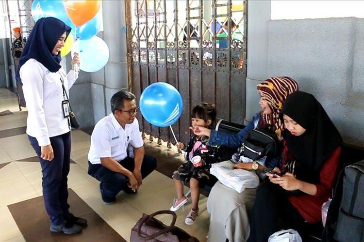 Kuswardoyo, Manager Humas PT KAI Daop III Cirebon memberikan balon kepada calon penumpang kereta api di Stasiun Kejaksaan Cirebon, Selasa (23/7/2019). Pemberian ini bagian dari upaya PT KAI memperingati Hari Anak Nasional.