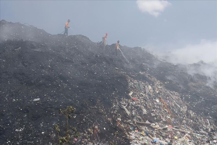 Petugas Damkar Surakarta melakukan pemadaman api yang membakar tumpukan sampah di Tempat Pembuangan Akhir (TPA) Putri Cempo Kelurahan Mojosongo, Kecamatan Jebres, Solo, Jawa Tengah, Selasa (30/7/2019).