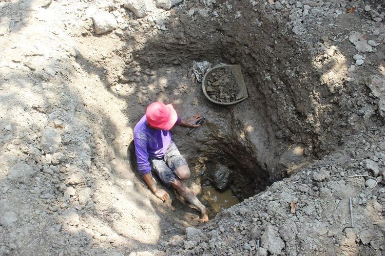 Seorang warga di Kp. CIsalak Hilir, Desa Cisalak, Kec. Cibeber, Kab. Cianjur, Jawa Barat sedang menggali tanah untuk mencari sumber air baru karena bencana kekeringan.