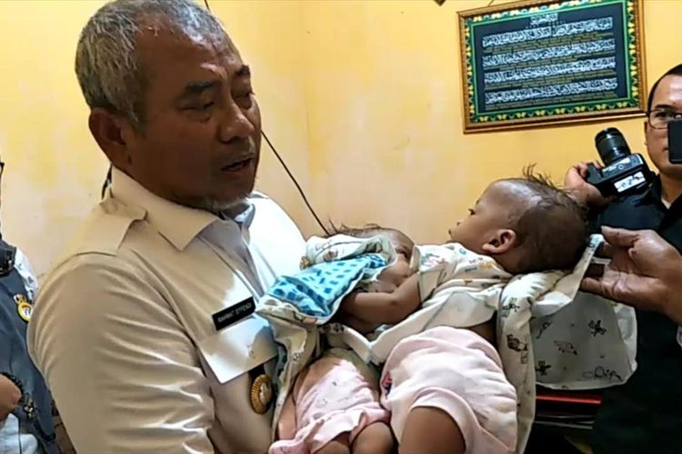 Wali Kota Bekasi Rahmat Effendi saat menggendong bayi kembar siam bernama Ahmad Rahman Al Ayyubi dan Ahmad Rahim Al Ayyubi di Bintara Jaya, Kota Bekasi, Rabu (31/7/2019).