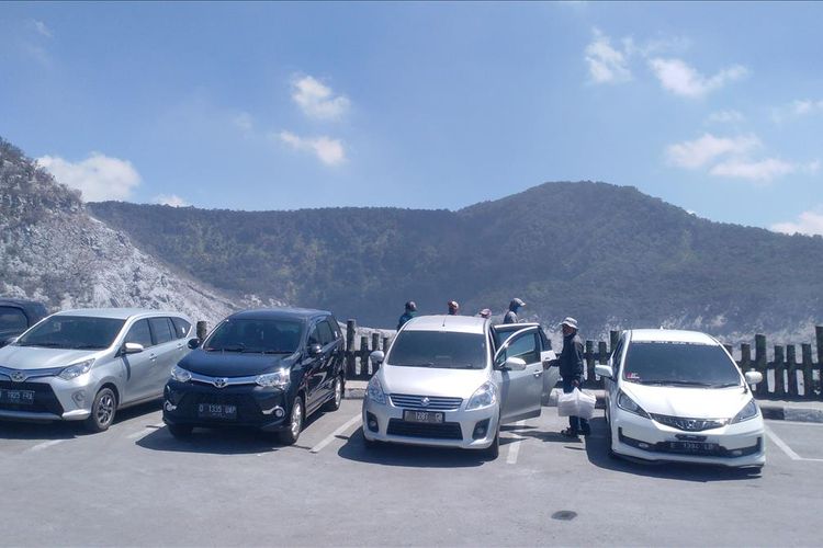 Mobil wisatawan yang diparkir membelakangi Kawah Ratu, pusat kunjungan wisata Gunung Tangkuban Parahu.