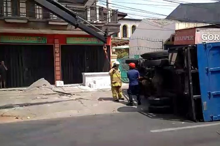 Sebuah Truk Muatan Material Besi Terguling di Jalan Malaka, Cipayung, Jakarta Timur, Jumat (2/8/2019).