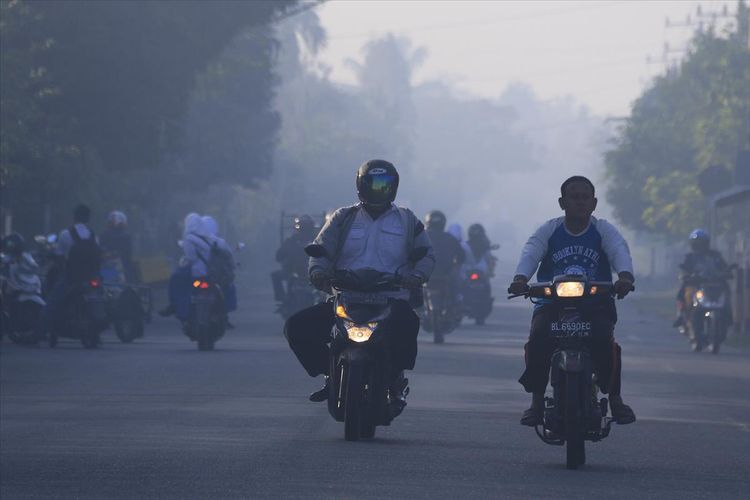 Ruas Jalan Banda Aceh - Meulaboh di Kawasan Kecamatan Samatiga, Kabupaten saat pagi dan malam hari diselimuti kabut asap kebaran lahan dan hutan gambut, Selasa (30/07/2019).