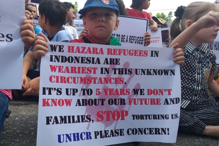 Salah satu anak imigran ikut demo di halaman kantor IOM di Graha Pena Riau, Pekanbaru, Riau, Kamis (8/8/2019).