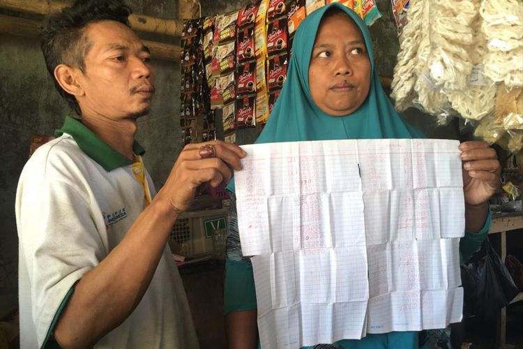 Suliono dan Suparmi, pemilik warung di dekat lokasi proyek pembangunan Rusunawa Kota Mojokerto, menunjukkan catatan tagihan pekerja proyek yang belum dibayar.