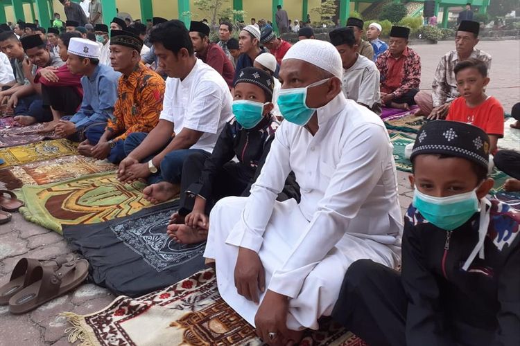 Warga mengenakan masker saat salat Hari Raya Idul Adha 1440 H di Halaman Museum Sang Nila Utama di Jalan Jenderal Sudirman, Kota Pekanbaru, Riau, Minggu (11/8/2019).