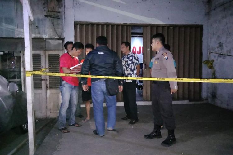 OLAH TKP--Nampak aparat Polres Madiun sementara melakukan olah tempat kejadian kasus penemuan mayat Darwin Nasution, driver ojek online yang ditemukan tewas bersimbah darah didalam kamarnya, Minggu (12/8/2019) malam.
