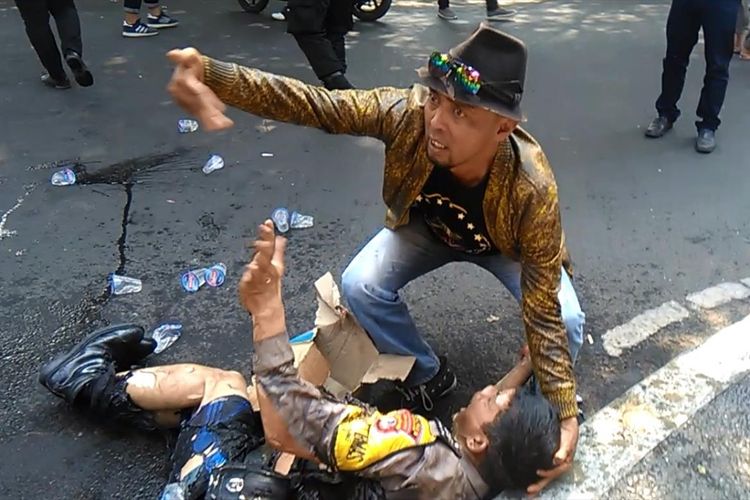 Seseorang coba memberikan pertolongan kepada seorang anggota polisi yang terbakar saat terjadi insiden kericuhan dalam aksi unjukrasa di ruas Jalan Siliwangi depan gerbang Pendopo Bupati Cianjur, Jawa Barat, Kamis (15/08/2019) siang(Firman Taufiqurrahman)