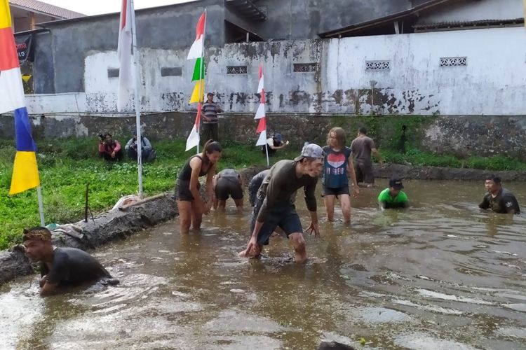 Sejumlah bule asal Belgia mengikuti lomba menangkap lele di kubangan lumpur dalam rangka HUT RI di Desa Kemutug Lor, Kecamatan Baturraden, Kabupaten Banyumas, Jawa Tengah, Sabtu (17/8/2019).