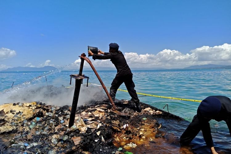 Anggota Brimobda dan Pol Air Polda Sultra berusaha memadamkan sisa api yang telah membakar KM Izhar di perairan Pulau Bokori, Kabupaten Konawe, Sultra. (Foto dok Polda Sultra)